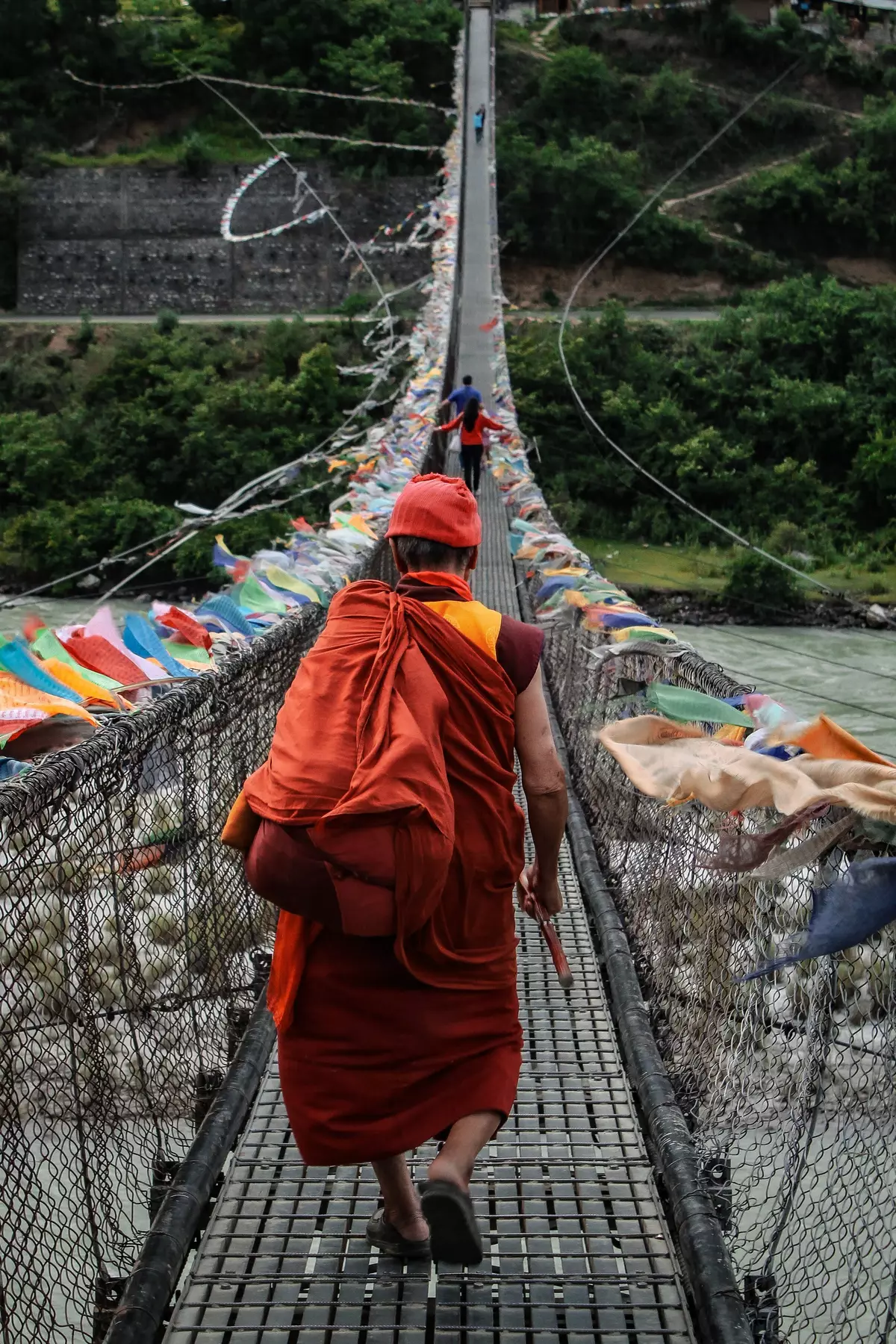 Monk crossing bridge, Punakha